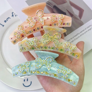Trois grandes pinces à cheveux en acétate avec papillons strass en orange, jaune et bleu