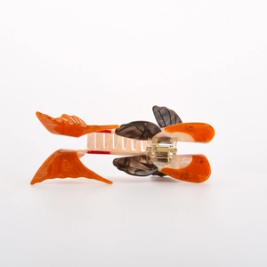 Dettaglio molletta per capelli a forma di pesce rosso in acetato arancione e bianco