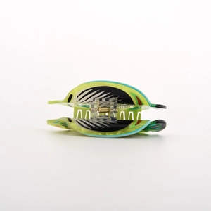 Dettaglio di una pinza per capelli a forma di pesce verde con strisce e molla in metallo
