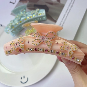 Vue macro détaillée d'une élégante pince à cheveux papillon avec strass et acétate de qualité