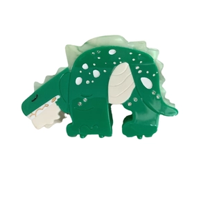 Green dinosaur hair claw clip made of acetic acid with rhinestones on white background