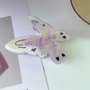 Détail de la pince à cheveux papillon avec finition nacrée en acétate brillant