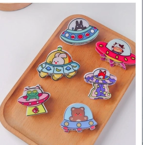 Close-up of cute cartoon UFO hair clips with animal characters on a wooden tray