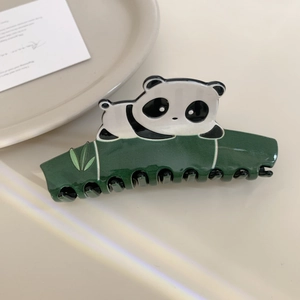 Detail of cute panda hair claw clip on bamboo branch with glossy acetate finish