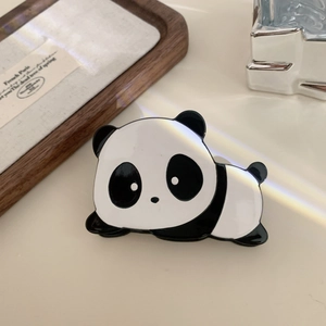 Close-up of a panda hair claw clip made of acetate with a glossy finish and rainbow light