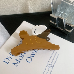 Détail d'une pince à cheveux ours marron avec un joli nuage blanc et visage souriant