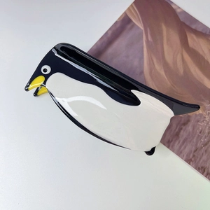 Detailed view of the cute penguin hair claw clip made of premium glossy acetate material