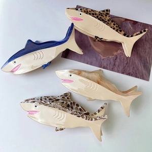 Set of four shark-shaped acetic acid hair clips in leopard, marble, and solid blue patterns