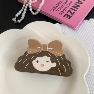 Vue détaillée d'une pince à cheveux motif fille mignonne sur une assiette blanche