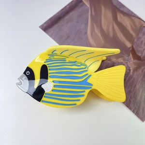 Detail of a tropical fish claw clip in vibrant yellow and blue acetate material