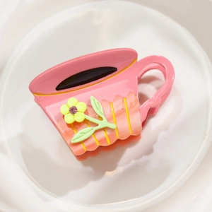 Pince à cheveux créative en forme de tasse à café rose avec détail floral sur plateau