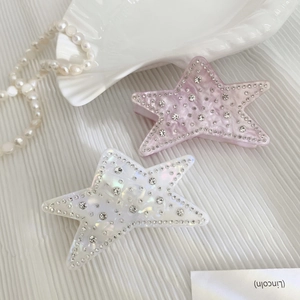 Sparkling star-shaped hair clips with rhinestones in purple and iridescent white colors
