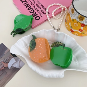Vibrant orange and green lime acetate fruit hair claws on a stylish shell tray