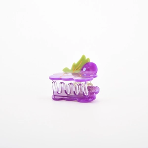 Dettaglio di una simpatica molletta per capelli a uva viola con foglia e pois bianchi