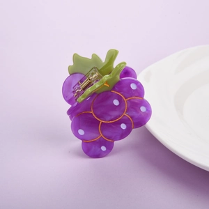 Dettaglio della molletta per capelli a uva viola con pois bianchi e molla dorata