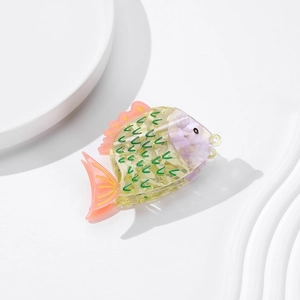 Détail de la pince à cheveux en acétate en forme de poisson aux tons jaune et violet