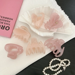 Lot de pinces à cheveux roses en résine en forme de cœur sur un plateau coquillage
