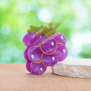 Graziosa pinza per capelli a forma di uva viola con texture marmorizzata su pietra bianca