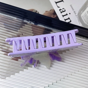 Detail of a purple square hair claw clip featuring a 3D gradient butterfly ornament
