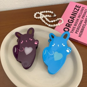 Cute bunny acetate hair claws in purple and blue with heart cutouts in a cream tray