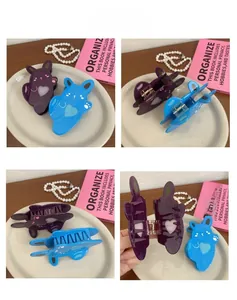 Detail view of rabbit-shaped hair claws in purple and blue with heart patterns
