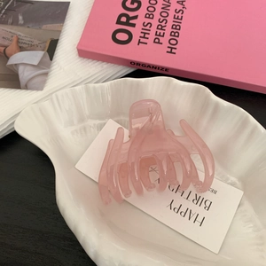 Pince à cheveux rose en forme de fleur sur un plateau de coquillage élégant