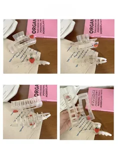 Detail view of cream acetate hair claws with red strawberry prints and spring design
