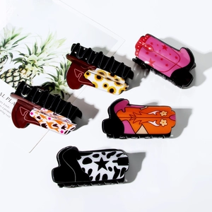 Cinq pinces à cheveux en forme de bottes avec motifs floraux et vache sur fond blanc