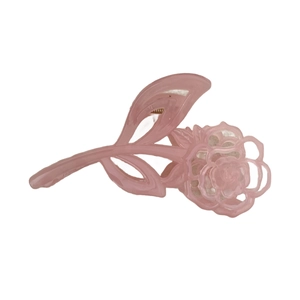 Pince à cheveux rose clair en forme de fleur avec design ajouré sur fond blanc