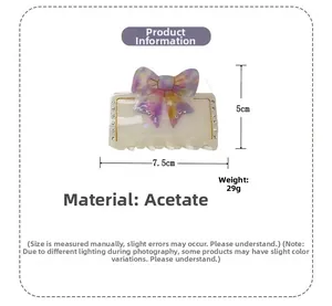 Détail d'une pince à cheveux en acétate avec nœud, strass et dimensions de 7,5 cm