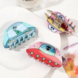Trois pinces à cheveux UFO alien en acrylique bleues, jaunes et roses sur assiette