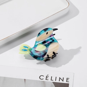 Chic acetate bird hair claw with elegant marble texture in blue and purple tones
