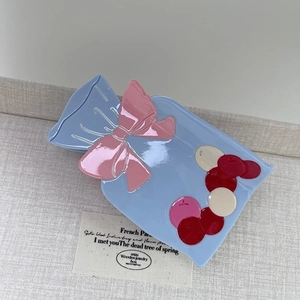 Pince à cheveux en acétate motif sachet de bonbons avec nœud rose et motifs colorés