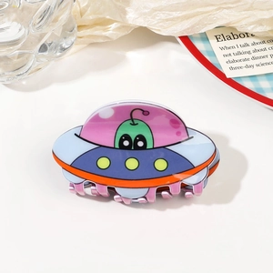 Détail macro de la pince à cheveux OVNI colorée avec un design d'alien en acrylique
