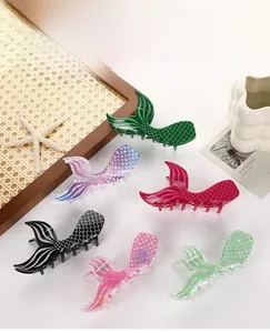 Detail of six acetate mermaid tail hair claws in vibrant colors for stylish women