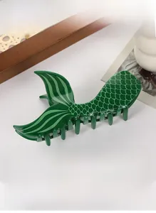 Detail of mermaid tail hair claw clip in dark green with realistic scale texture