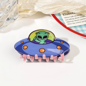 Détail d'une pince à cheveux OVNI en acrylique bleu foncé avec motif d'extraterrestre