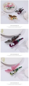 Detail of multi-colored acetate dragonfly hair clips on a white ceramic plate