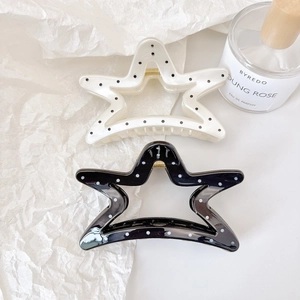 Polka dot star hair claw clips with gold metal springs on luxury textured paper