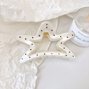 Star-shaped pearl white hair claw clip with black polka dots and gold spring detail