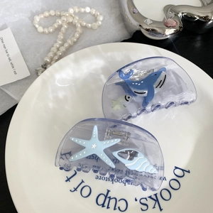 Set of two ocean-themed hair claws featuring blue whales and starfishes in translucent acrylic