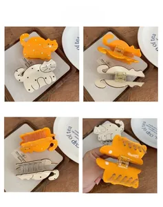 Detail view of cat shaped hair claws with polka dots showing the spring and inner teeth