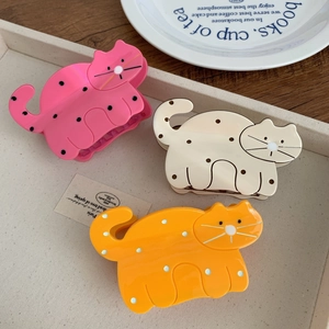 Three cute acetate cat hair claws in pink, cream, and orange with black polka dots