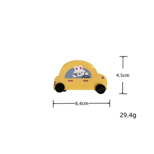 Détail d'une pince à cheveux voiture jaune avec lapin et dimensions de 8,4 cm par 4,5 cm