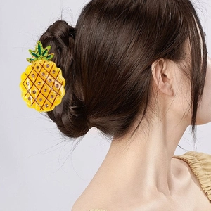 Pince à cheveux ananas jaune avec feuilles vertes et strass sur une coiffure