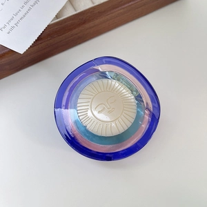 Détail d'une pince à cheveux en acétate avec emblème soleil et cercles en résine