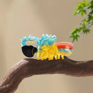 Papageien-Haarklammer aus Acetat mit tropischen Farben auf einem Holzzweig