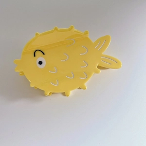 Macro shot of creative yellow puffer fish hair claw clip showing detailed spikes and texture