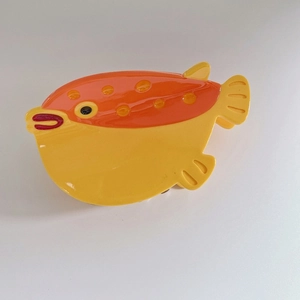 Detail of yellow pufferfish hair claw clip made of acetic acid plate with orange spots