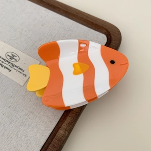 Detail view of clownfish hair claw clip made of glossy acetate in orange and white